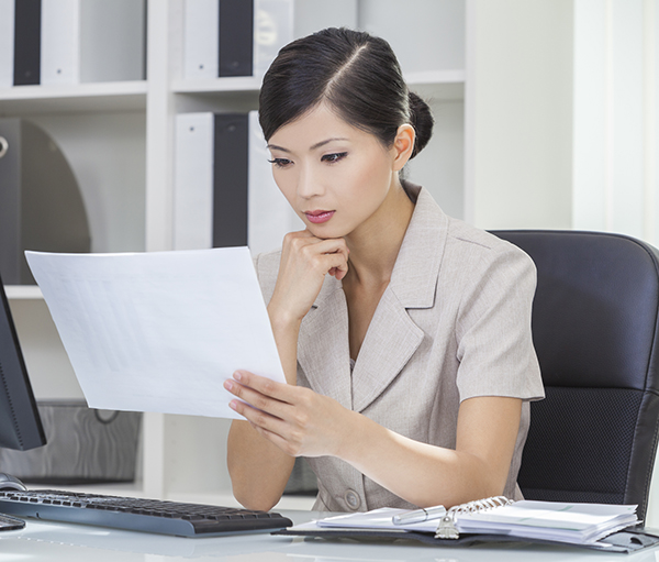 woman at her desk reading a documen t